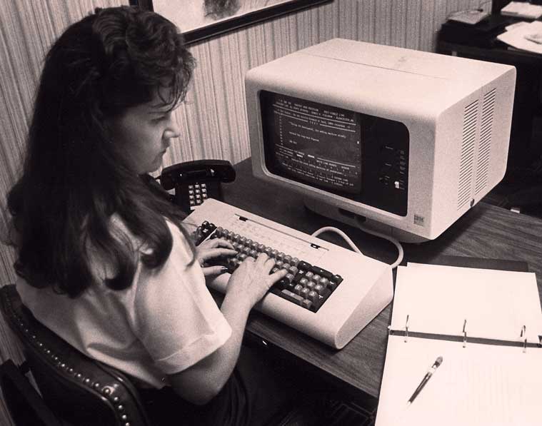 Black and white photo of woman at computer