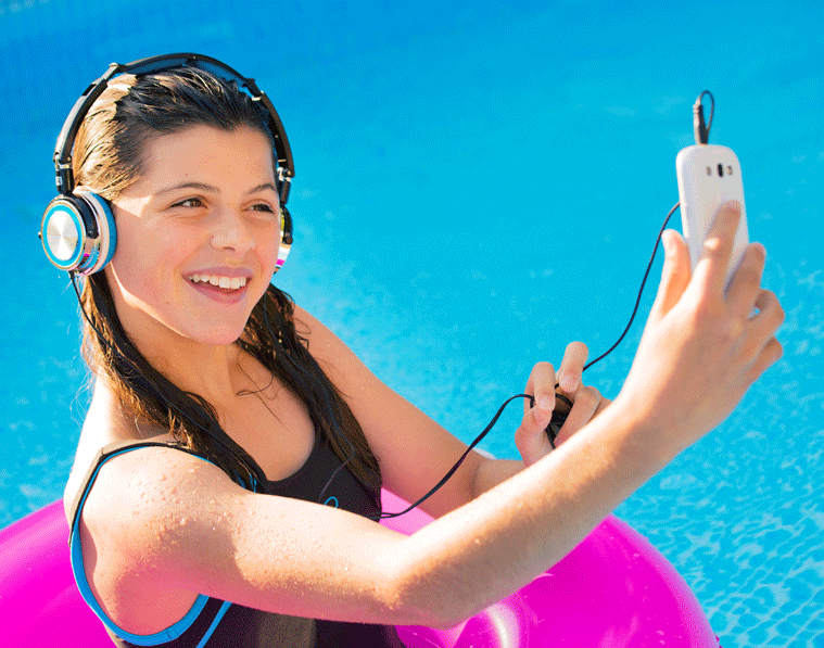 Teenager using cellphone in pool