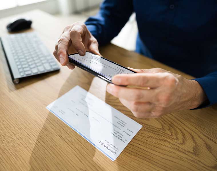 Person capturing paper check image with phone